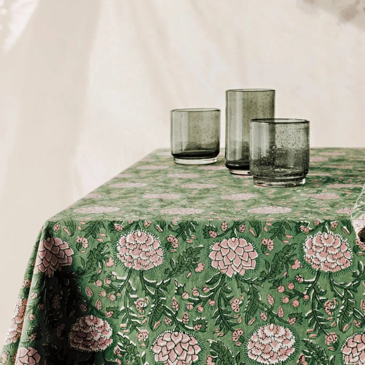 Table setting with a floral tablecloth and glasses.