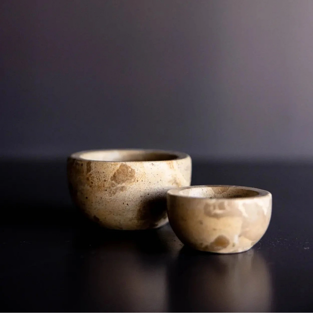 Brown and beige marble pinch bowls on dark background.