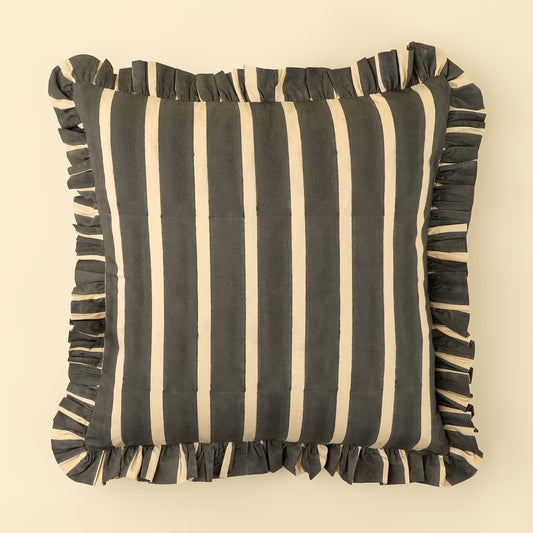 A square decorative throw pillow with vertical charcoal and cream stripes and matching ruffled trim on all sides, shown against a solid light beige background.