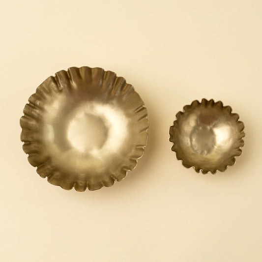 Two scalloped metal bowls in different sizes, shown on a plain beige background.