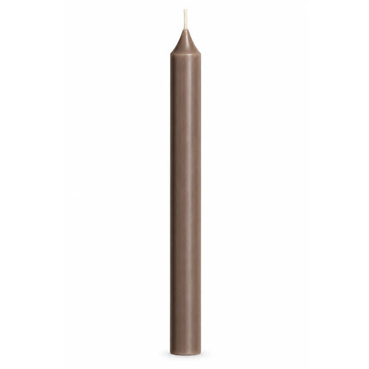 A single tall, slender beige-brown taper candle with a white wick, centered against a solid white background.