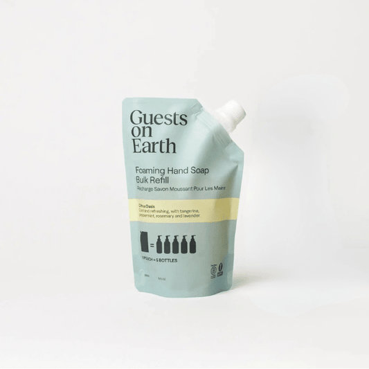 Guests on Earth Foaming Hand Soap Bulk Refill pouch in a pale mint green color with a yellow stripe and white cap, on a clean white background.