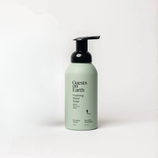 Guests on Earth Foaming Hand Soap in a light sage green bottle with a black pump dispenser, set against a clean white background.