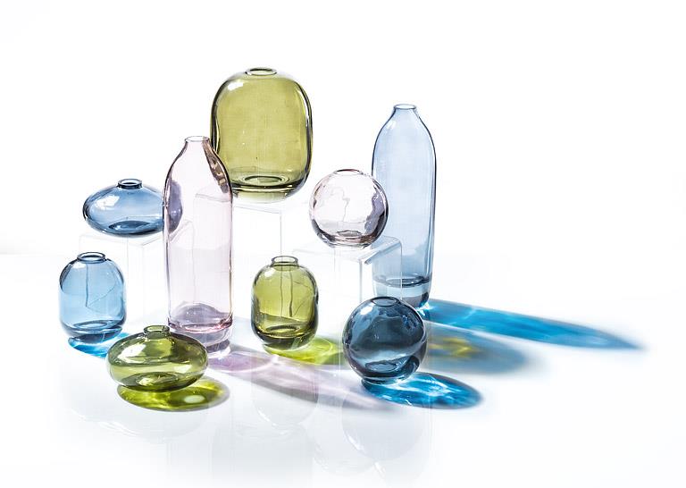 Collection of colourful glass vases on a white background.