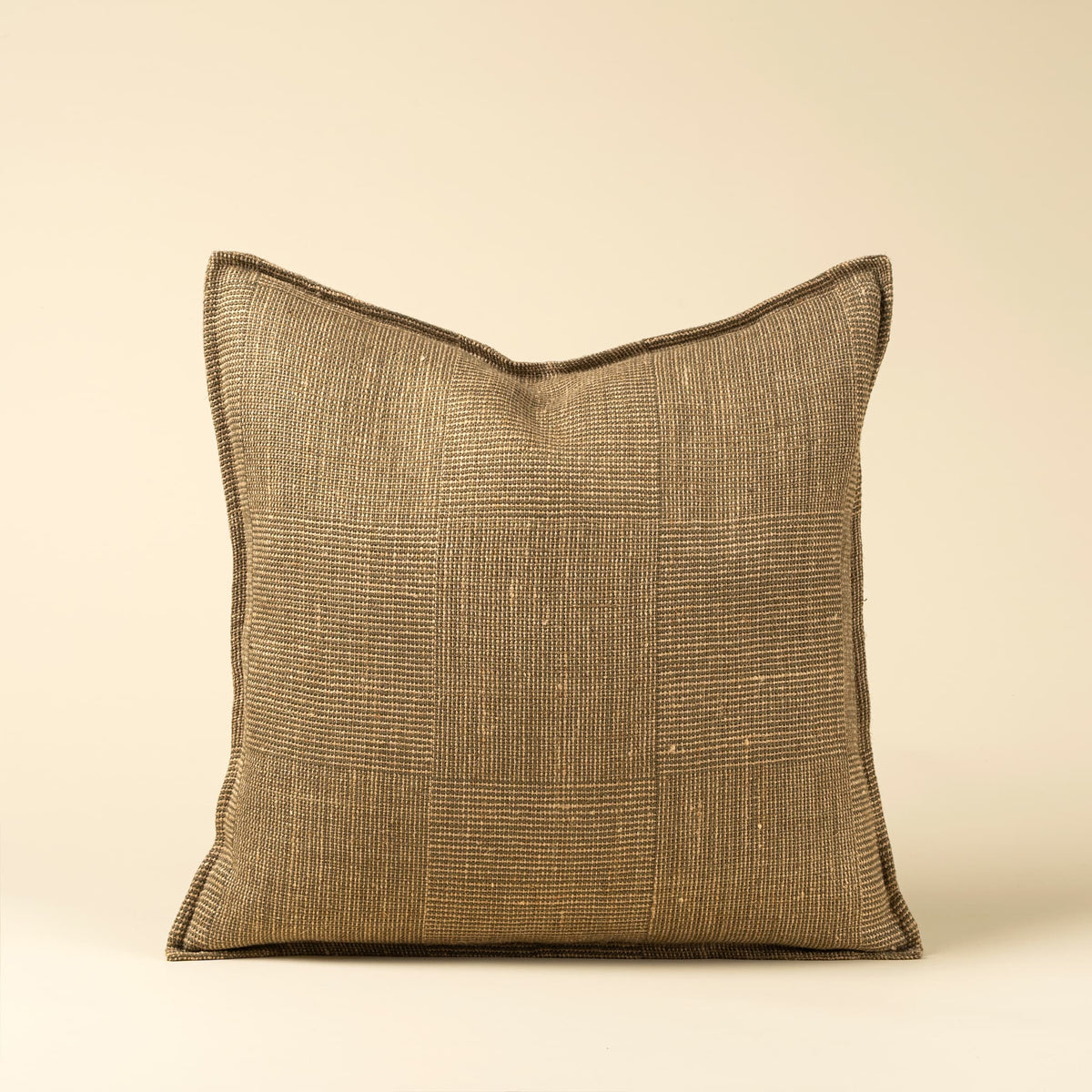 A square throw pillow with a textured, woven patchwork-style flax linen fabric in a warm olive and taupe color, shown against a solid cream background.