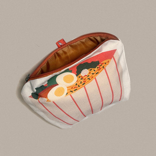 A white zippered pouch with a ramen bowl illustration, shown open against a solid gray background.