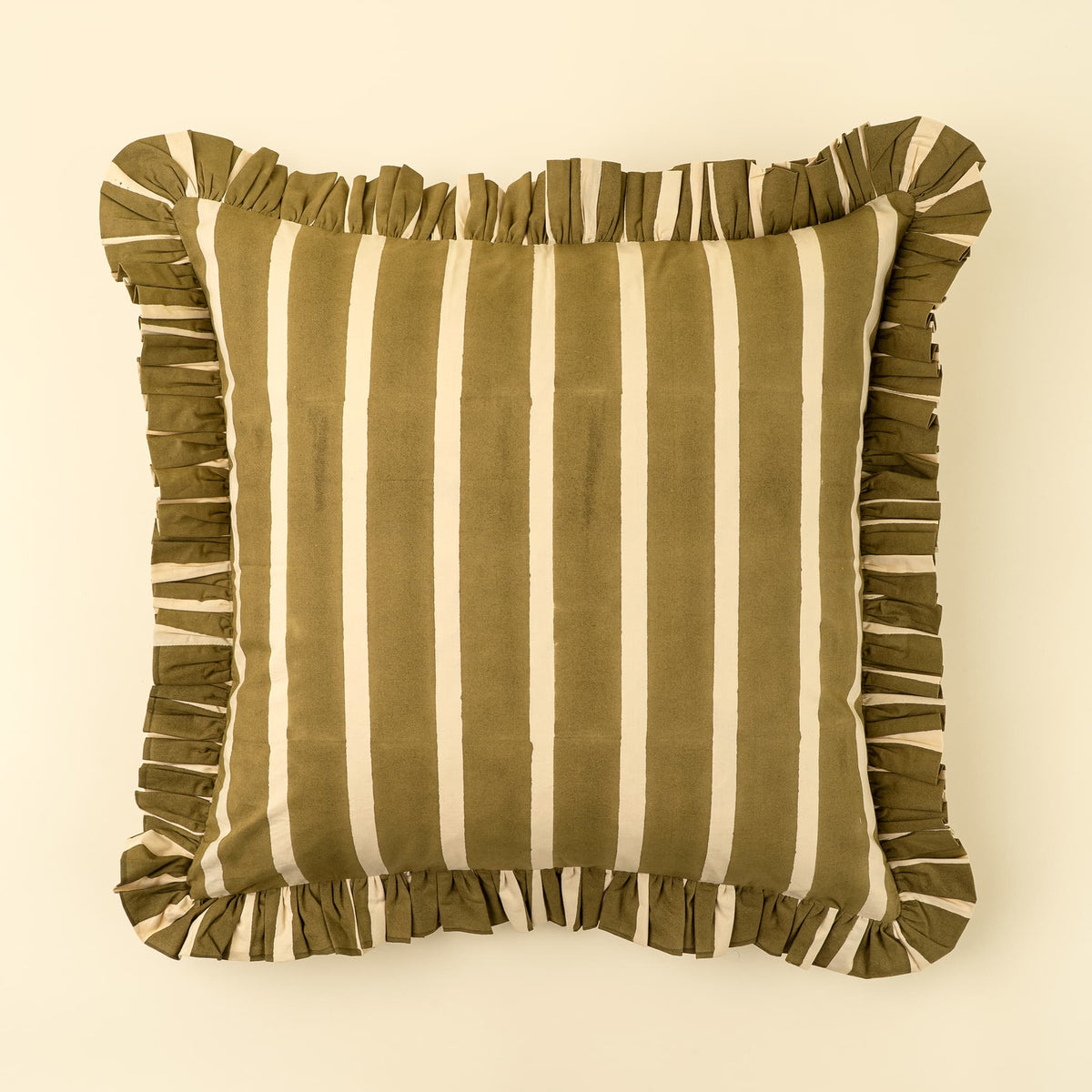 A square throw pillow with vertical olive green and cream stripes, finished with a ruffled fabric border, shown against a solid cream background.