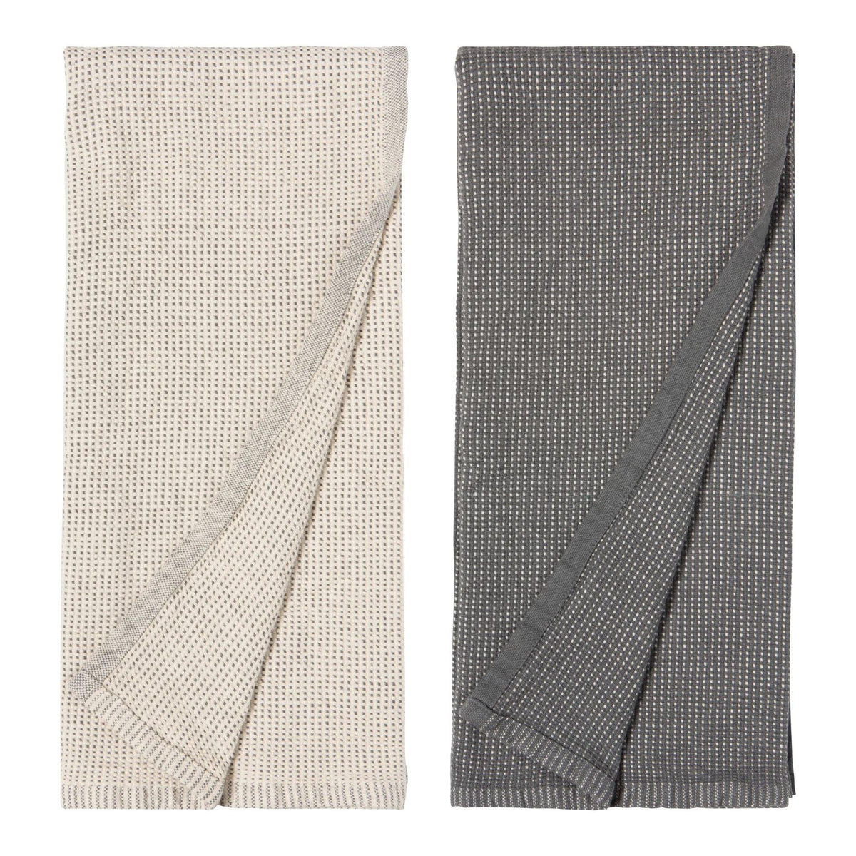 Two folded textured hand towels shown side by side on a plain white background. The left cloth is warm off-white/cream, and the right cloth is dark gray, both with a small repeating woven pattern.