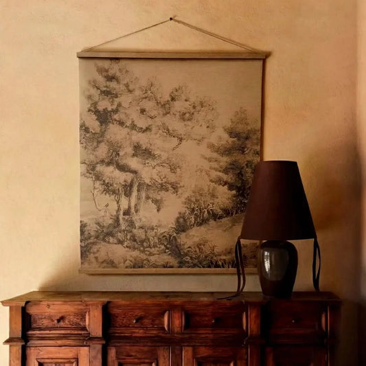 Moody room with wooden cabinet, lamp, and wall art.